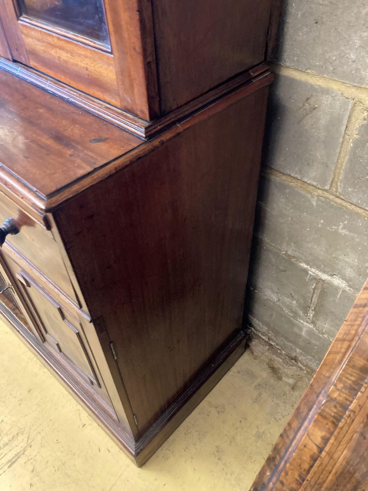 A Victorian mahogany bookcase cupboard, with pull out mid section writing slide, width 144cm depth 50cm height 245cm
